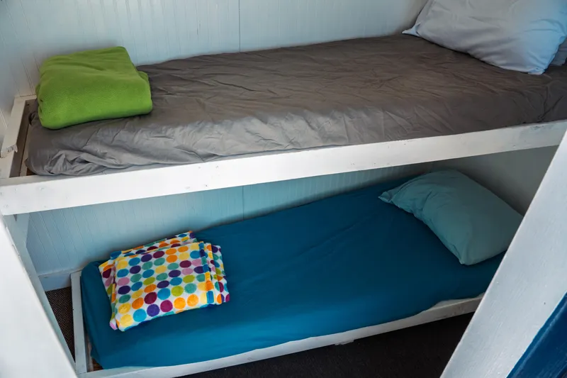 Slide: The Image of Bunk beds in a 1977 Saint Augustine 43 Trawler, featuring colorful bedding and cozy setup. - 51
