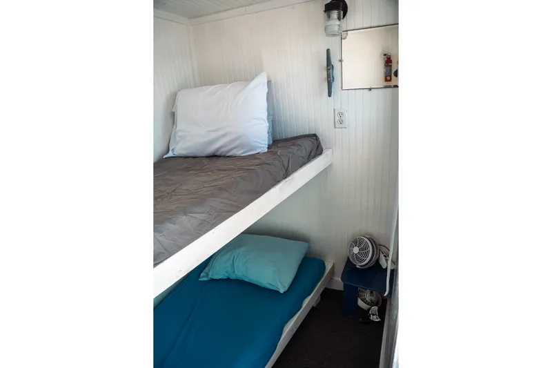 Slide: The Image of 1977 Saint Augustine Trawler 43 cabin with bunk beds and compact fan. - 52