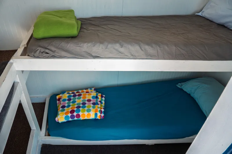 Slide: The Image of Bunk beds with colorful linens inside a 1977 Saint Augustine 43 Trawler. - 53