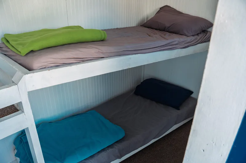 Slide: The Image of Bunk beds with colorful blankets inside a 1977 Saint Augustine 43 Trawler. - 55