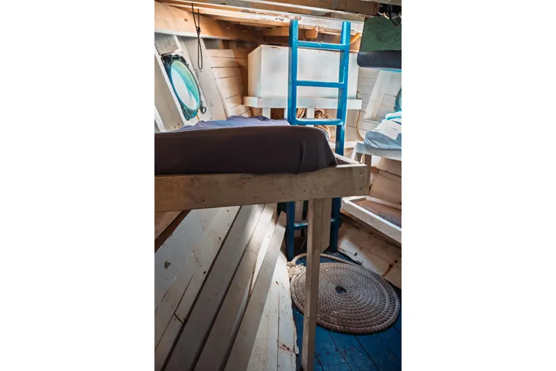Slide: The Image of 1977 Saint Augustine Trawler 43 interior with wooden bunk, blue ladder, and porthole window. - 69