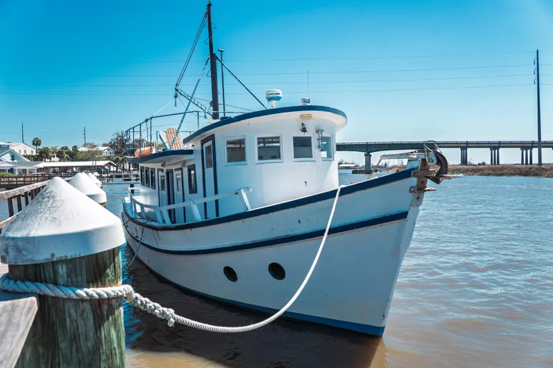 Slide: The Image of 1977 Saint Augustine 43 Trawler docked by a pier under a clear blue sky. - 7