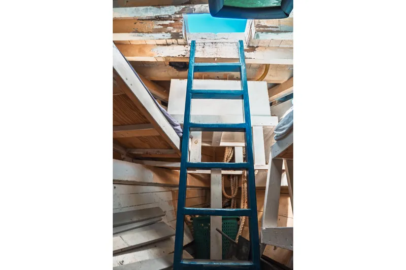 Slide: The Image of Interior view of 1977 Saint Augustine 43 Trawler, featuring a blue ladder and wooden structure. - 70