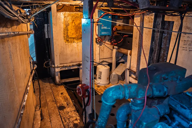 Slide: The Image of Engine room of a 1977 Saint Augustine 43 Trawler, showcasing machinery and wiring. - 72