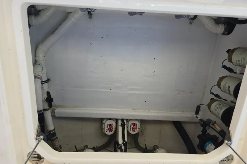 Slide: The Image of 2012 Fountain 38 CC Tournament Edition boat compartment with plumbing and filters. - 14