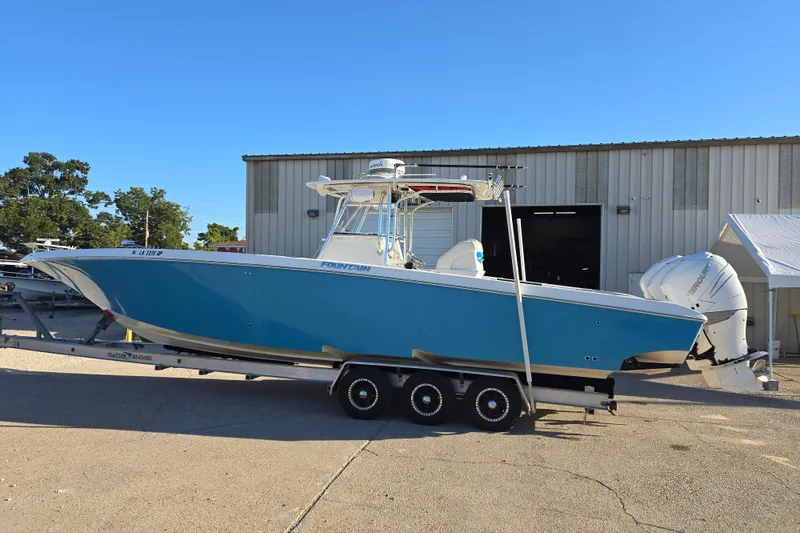 Slide: The Image of 2012 Fountain 38 CC Tournament Edition boat on trailer, parked outside a warehouse. - 3