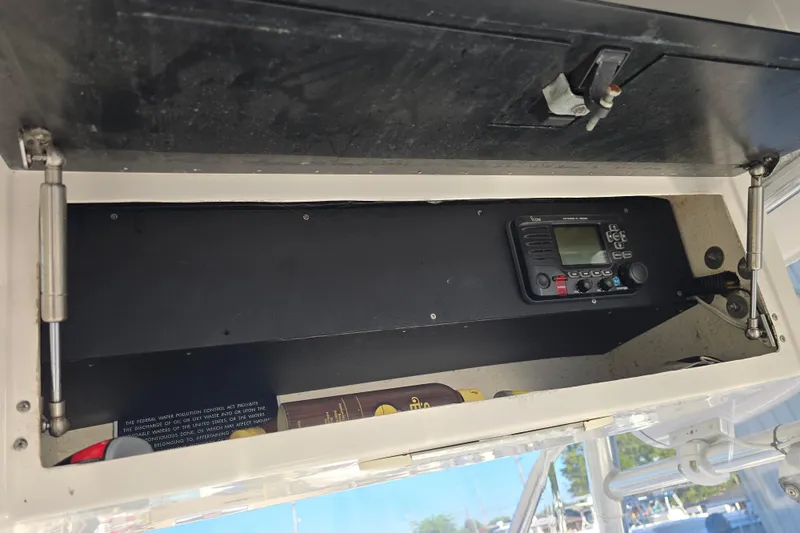 Slide: The Image of Storage compartment with radio equipment on a 2012 Fountain 38 CC Tournament Edition boat. - 33