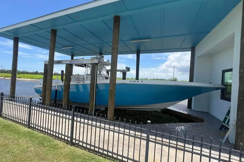 Slide: The Image of 2012 Fountain 38 CC Tournament Edition boat docked under a blue canopy. - 39