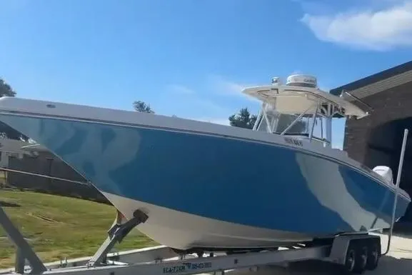 Slide: The Image of 2012 Fountain 38 CC Tournament Edition boat on trailer, blue hull, parked outdoors. - 47