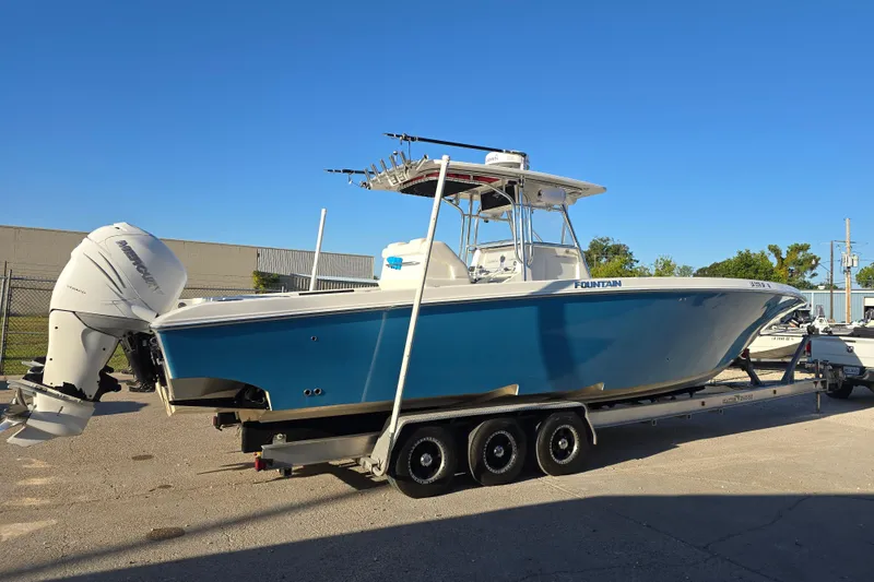 Slide: The Image of 2012 Fountain 38 CC Tournament Edition boat on trailer, featuring sleek blue hull and powerful outboard engines. - 6