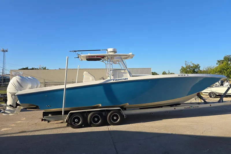 Slide: The Image of 2012 Fountain 38 CC Tournament Edition boat on trailer, blue hull, twin engines. - 7