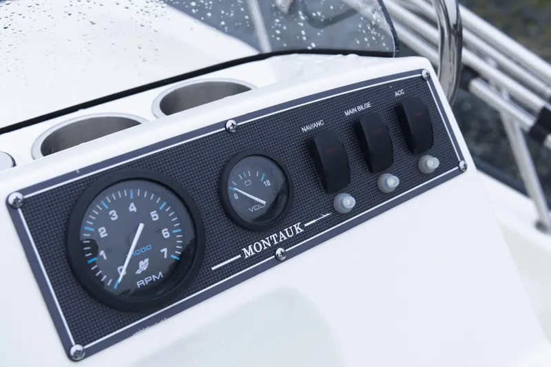 Slide: The Image of Dashboard of a 2021 Boston Whaler 150 Montauk boat with gauges and switches. - 10