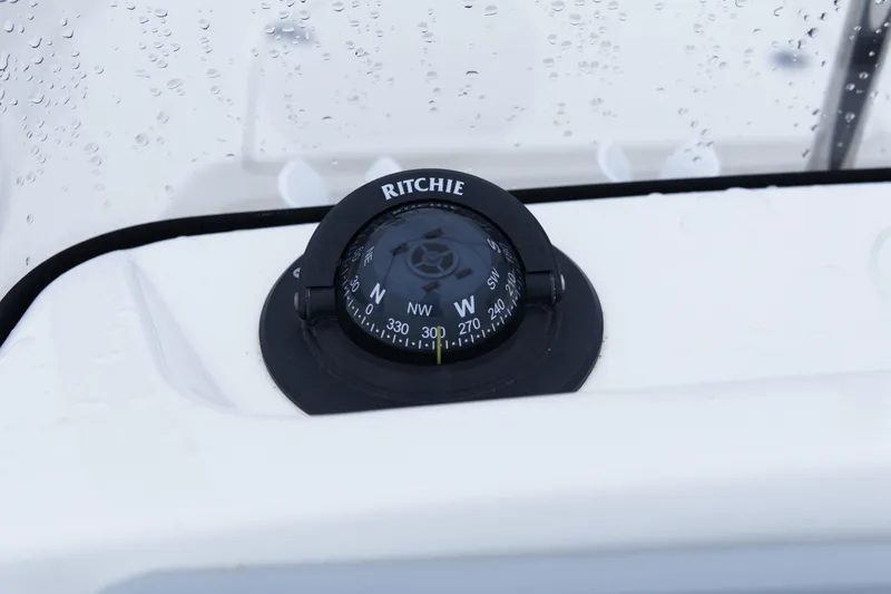 Slide: The Image of Compass on 2021 Boston Whaler 150 Montauk boat dashboard, with raindrops visible. - 11