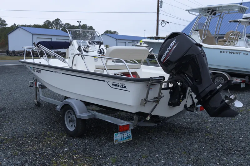 Slide: The Image of 2021 Boston Whaler 150 Montauk boat on trailer with Mercury outboard motor. - 2