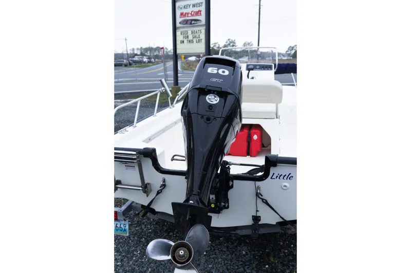 Slide: The Image of 2021 Boston Whaler 150 Montauk with 60 HP outboard motor, displayed outdoors. - 4