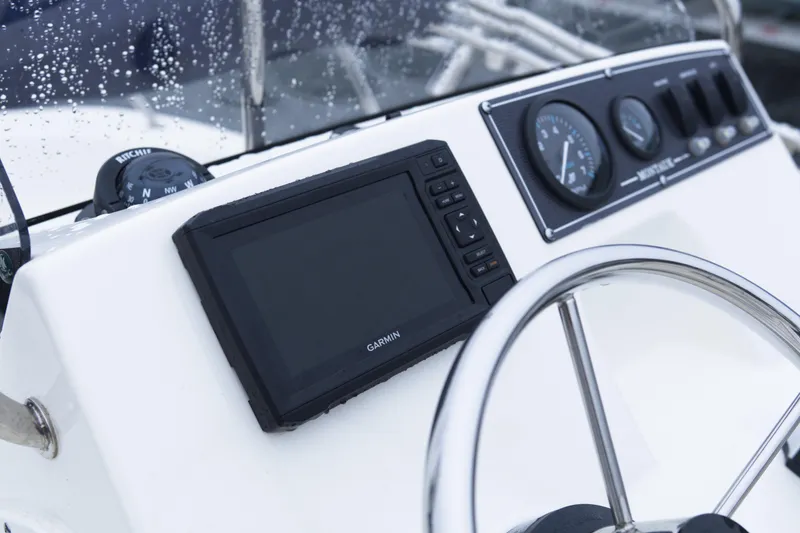 Slide: The Image of 2021 Boston Whaler 150 Montauk dashboard with Garmin display and steering wheel. - 9
