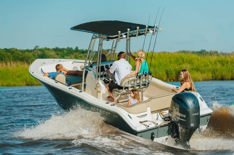 Slide: The Image of Family enjoying a ride on a 2026 Key West 203 FS boat in a scenic waterway. - 11