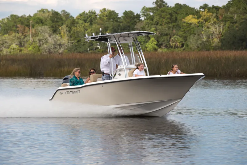 Slide: The Image of 2026 Key West 203 FS boat cruising on a serene lake with passengers onboard. - 7