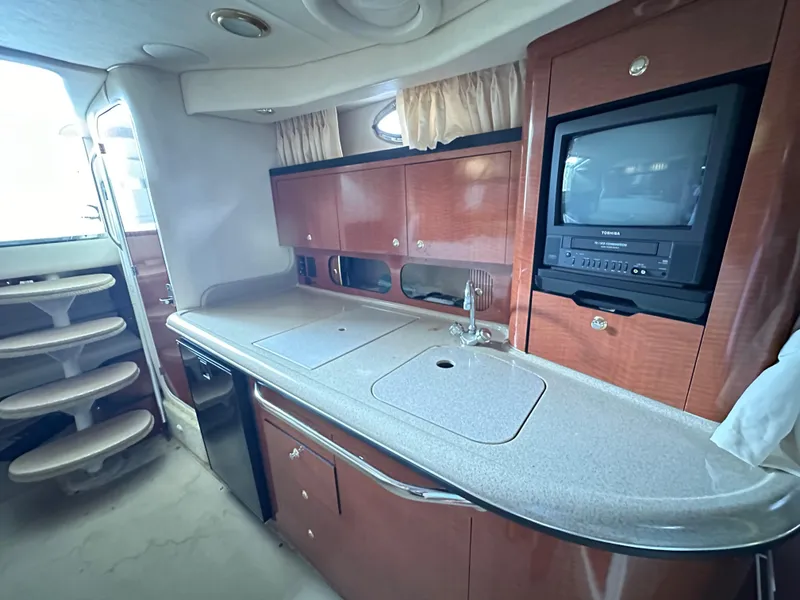 Slide: The Image of Interior of 2003 Sea Ray 340 Sundancer yacht with kitchenette and TV. - 12