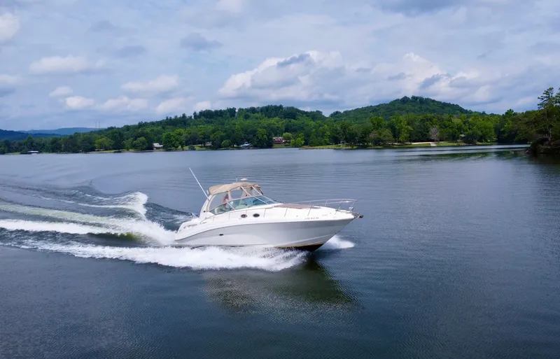 Slide: The Image of 2003 Sea Ray 340 Sundancer cruising on a serene lake. - 3