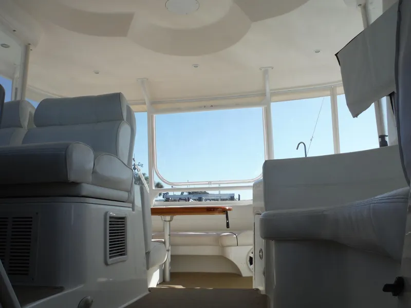 Slide: The Image of Interior of 2005 Cruisers Yachts 455 Express Motoryacht with white seating and large windows. - 16