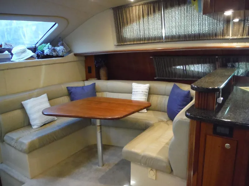 Slide: The Image of 2005 Cruisers Yachts 455 Express Motoryacht interior with dining area and cushioned seating. - 21