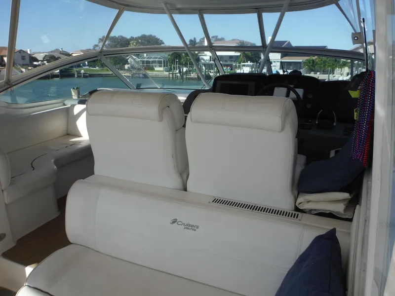Slide: The Image of 2005 Cruisers Yachts 455 Express Motoryacht interior with white seating and waterfront view. - 3