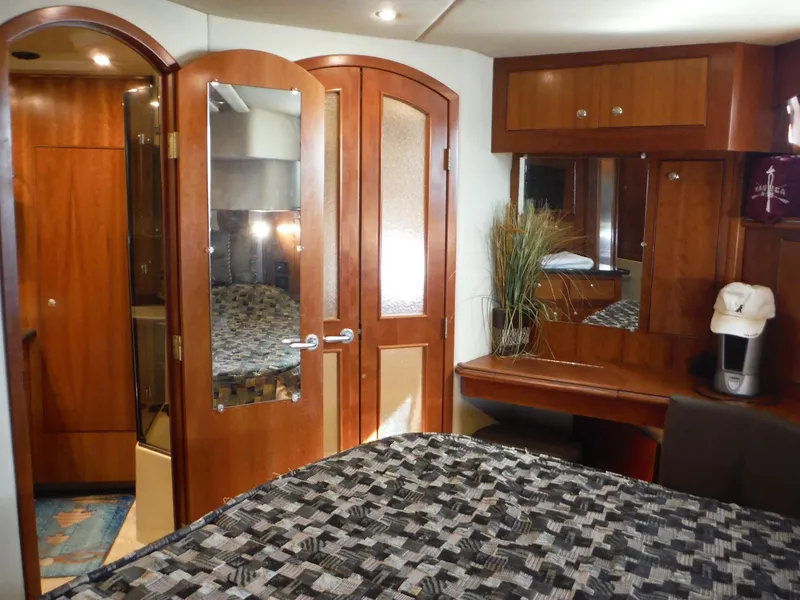 Slide: The Image of Luxurious 2005 Cruisers Yachts 455 Express Motoryacht bedroom with wooden decor and ensuite bathroom. - 35