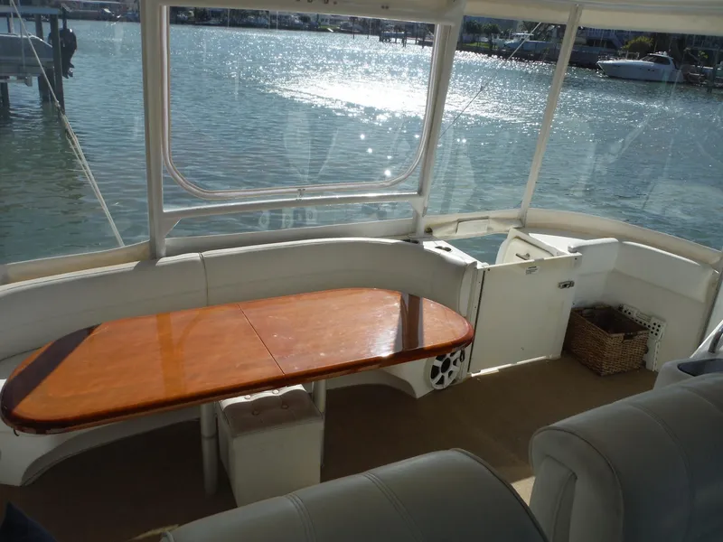 Slide: The Image of 2005 Cruisers Yachts 455 Express Motoryacht interior with wooden table and waterfront view. - 9