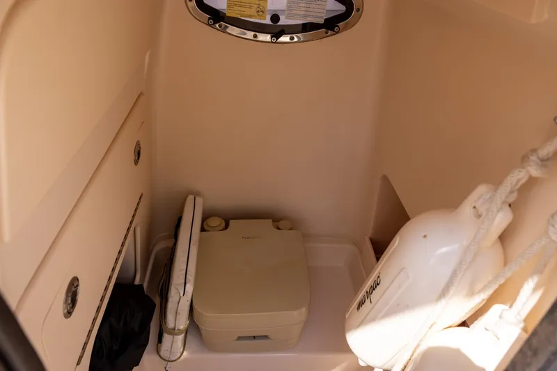 Slide: The Image of 2021 Grady-White 251 Coastal Explorer boat interior with portable toilet and storage. - 12