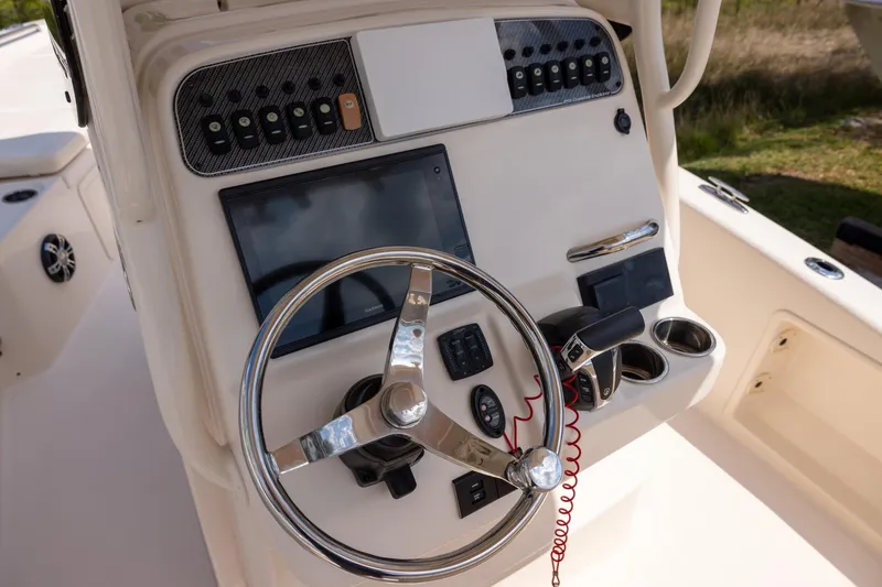 Slide: The Image of 2021 Grady-White 251 Coastal Explorer boat helm with steering wheel and control panel. - 7