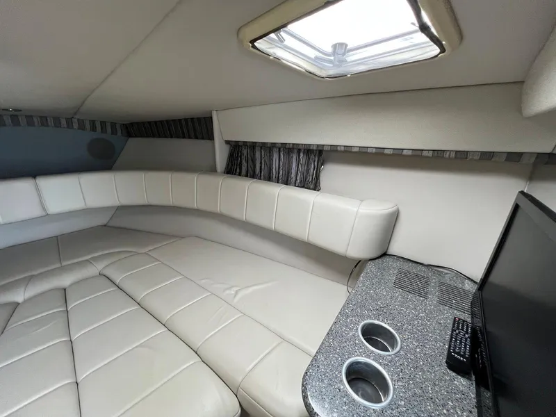 Slide: The Image of Interior of a 2005 Formula 330 Sun Sport boat with white leather seating and a small table. - 25