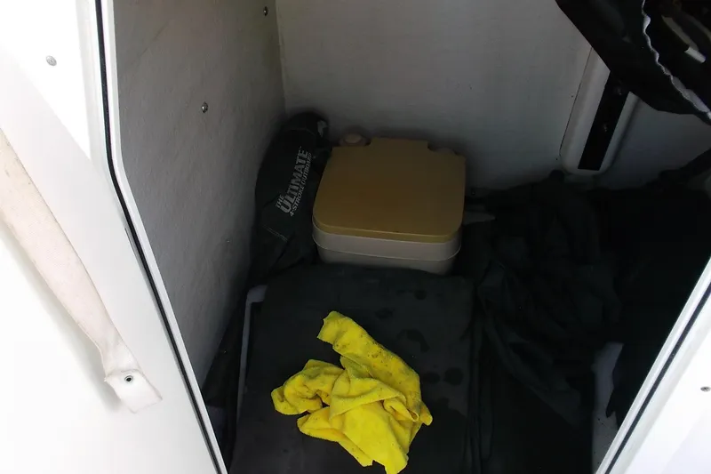 Slide: The Image of Interior of 2018 Twin Vee 260 CC SE boat with portable toilet and cleaning supplies. - 18