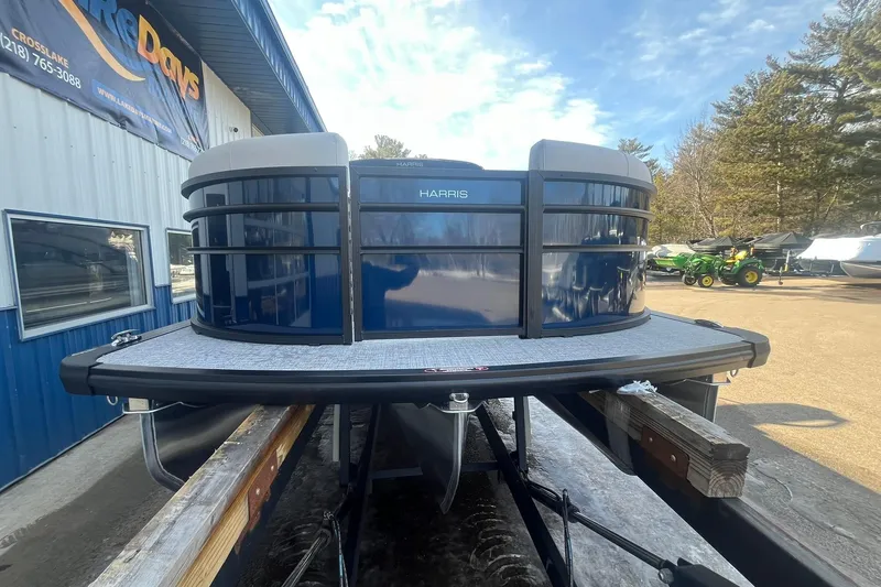 Slide: The Image of 2026 Harris Cruiser 230 CWDH pontoon boat at a dealership, under a clear sky. - 11