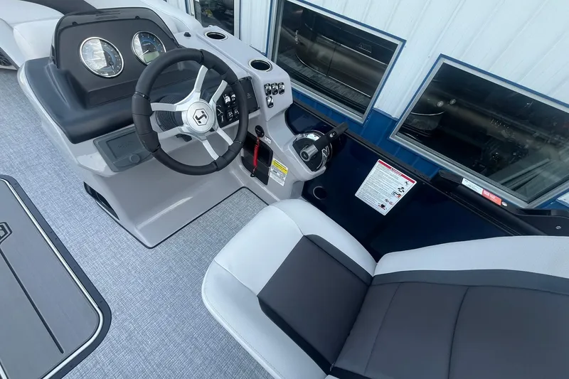 Slide: The Image of 2026 Harris Cruiser 230 CWDH boat interior with steering wheel and seating. - 22