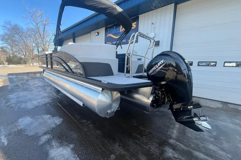 Slide: The Image of 2026 Harris Cruiser 230 CWDH pontoon boat with Mercury engine, parked outdoors. - 7
