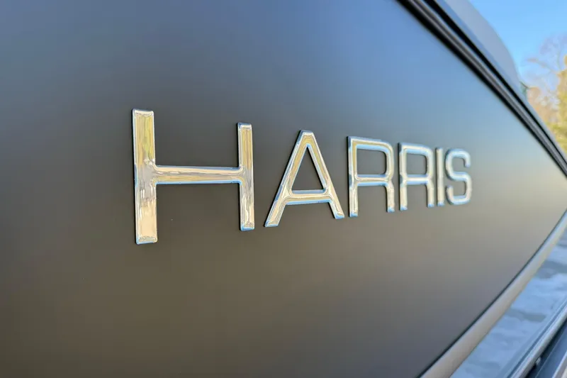 Slide: The Image of Close-up of "Harris" logo on 2026 Sunliner 230 boat exterior. - 16