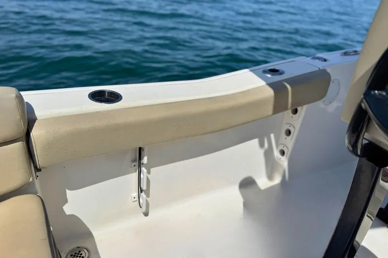 Slide: The Image of 2019 Tidewater 220 LXF boat interior with beige seating and cup holders. - 19