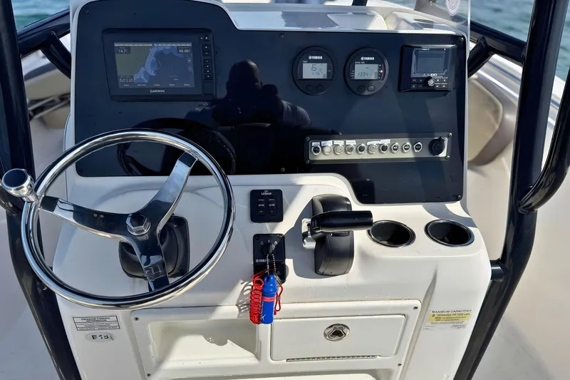 Slide: The Image of 2019 Tidewater 220 LXF boat dashboard with steering wheel and navigation controls. - 21