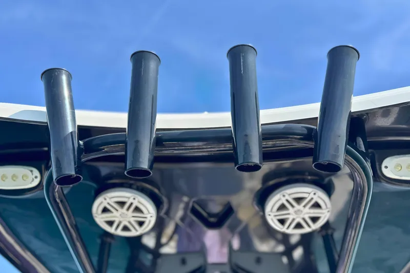 Slide: The Image of Rod holders and speakers on a 2019 Tidewater 220 LXF boat against blue sky. - 26