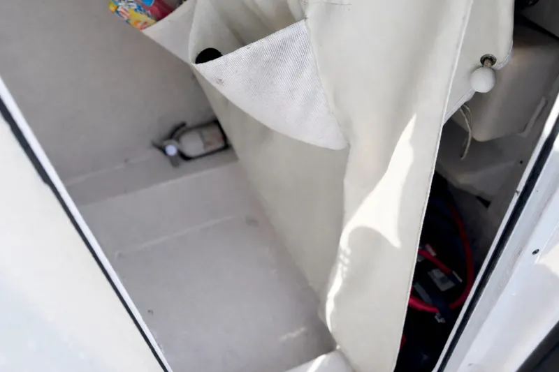Slide: The Image of Interior view of a 2019 Tidewater 220 LXF boat storage compartment with canvas cover. - 29