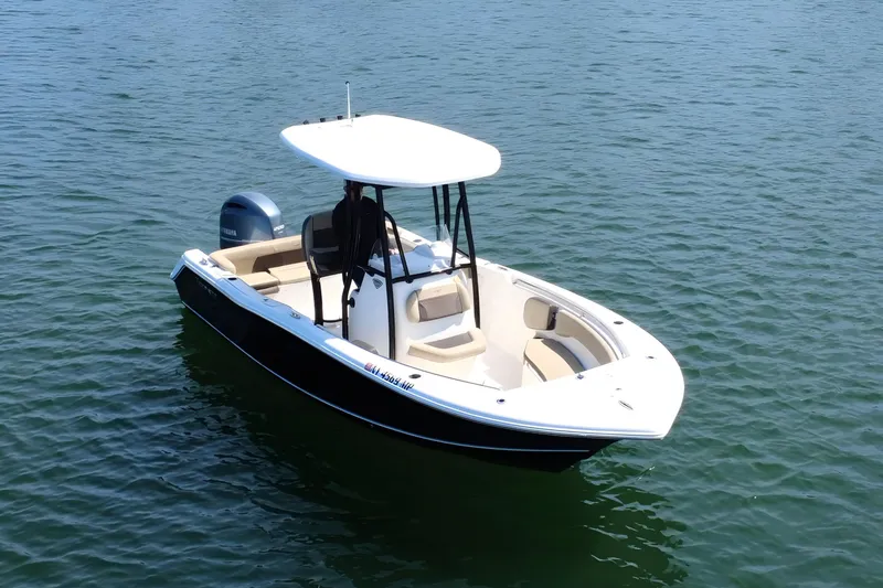 Slide: The Image of 2019 Tidewater 220 LXF boat on calm water, featuring sleek design and spacious seating. - 5