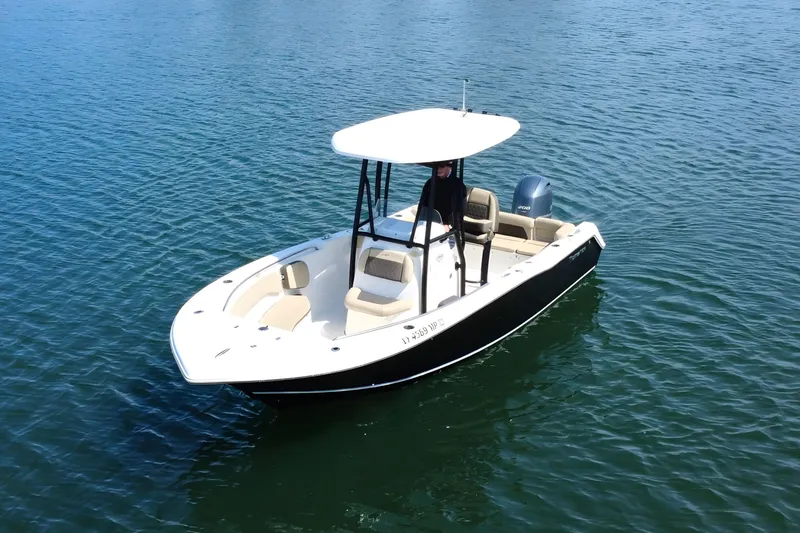 Slide: The Image of 2019 Tidewater 220 LXF boat on calm water, featuring a sleek design and T-top. - 9