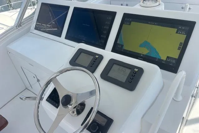 Slide: The Image of Control panel of 2006 Hatteras 50 Convertible yacht with navigation screens and steering wheel. - 11