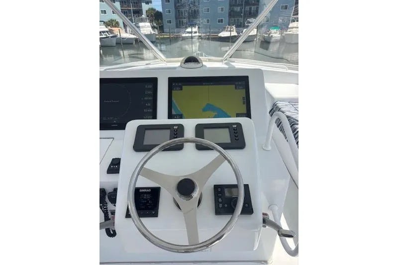Slide: The Image of Helm of 2006 Hatteras 50 Convertible yacht with navigation screens and steering wheel. - 12