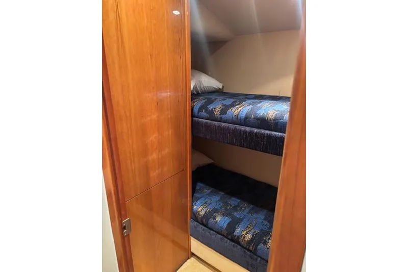 Slide: The Image of Bunk beds in 2006 Hatteras 50 Convertible yacht cabin with wooden door. - 23