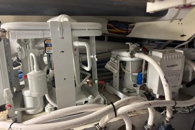 Slide: The Image of Engine room of 2006 Hatteras 50 Convertible yacht, showcasing complex machinery and piping. - 32