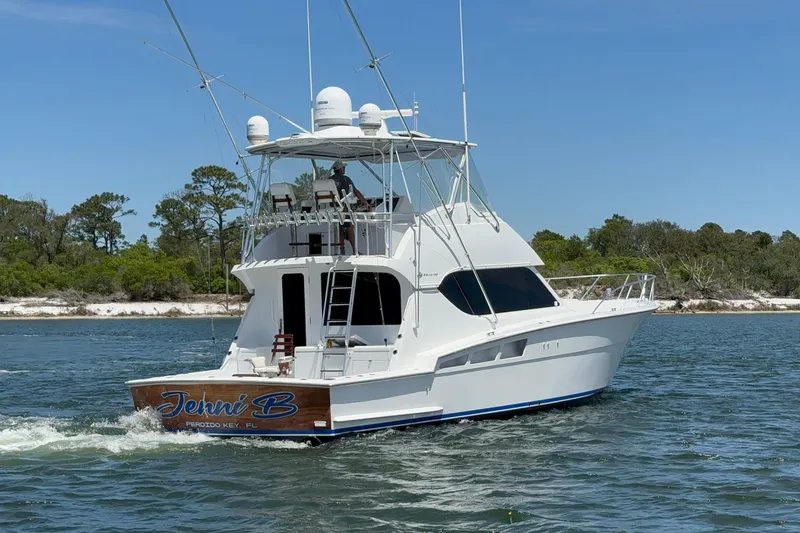Slide: The Image of A 2006 Hatteras 50 Convertible yacht cruising on a scenic waterway. - 4