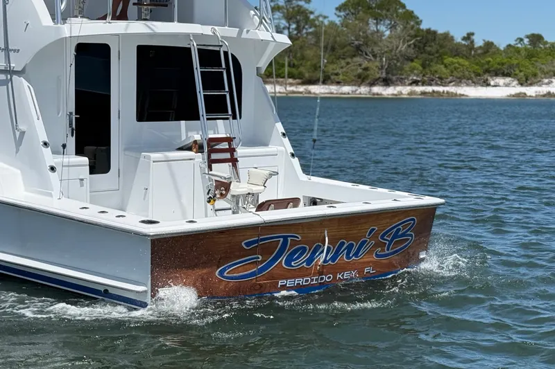 Slide: The Image of 2006 Hatteras 50 Convertible yacht named "Jenni B" cruising in coastal waters. - 6
