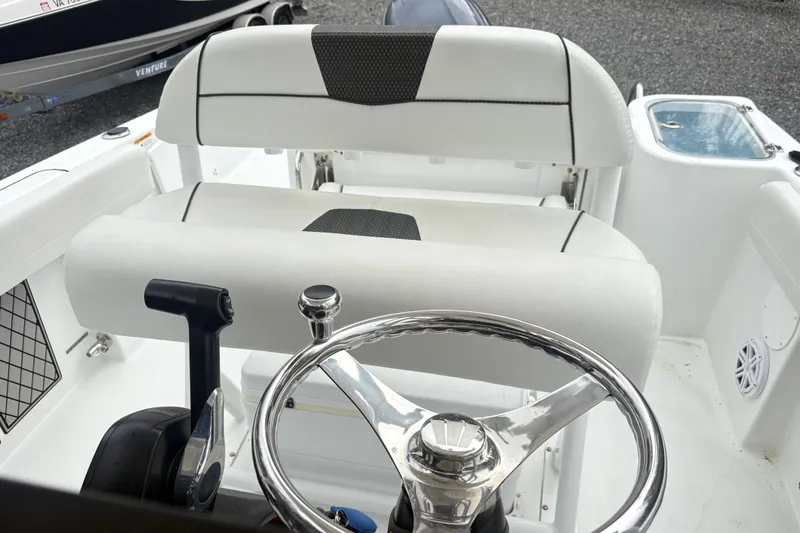 Slide: The Image of 2022 Wellcraft 222 Fisherman boat interior with steering wheel and seating. - 14